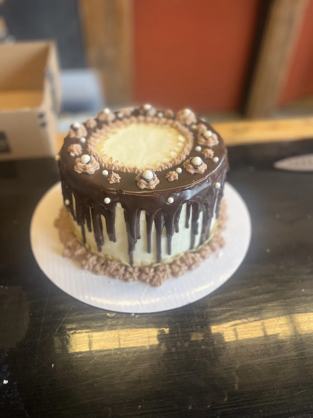Chocolate ganache drip cake with piped rosettes and white sugar pearls