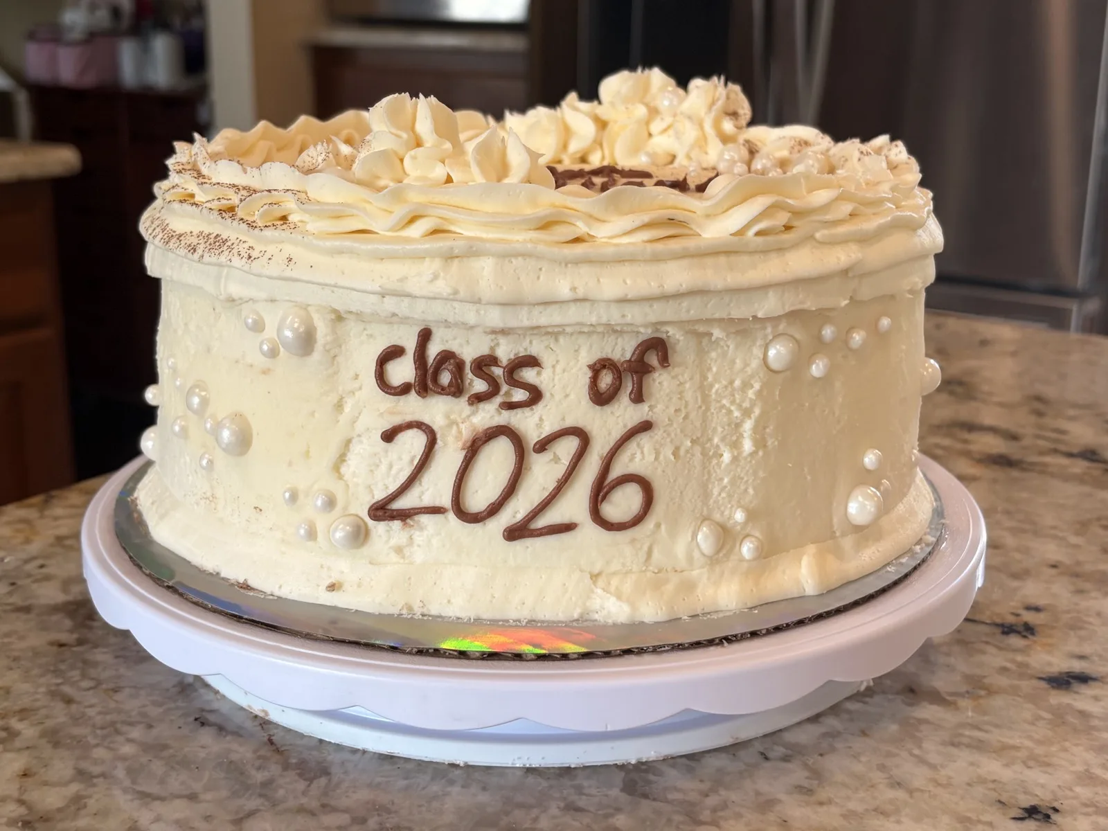 Cream buttercream cake piped with 'Class of 2026' and finished with sugar pearls