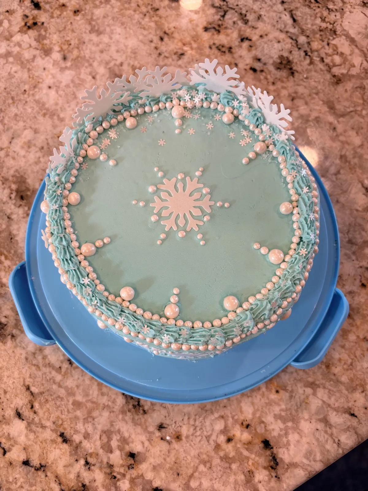 Overhead view of the ice blue snowflake cake with a large white snowflake centered on top